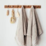 wooden hanger with towels and natural bathroom tools